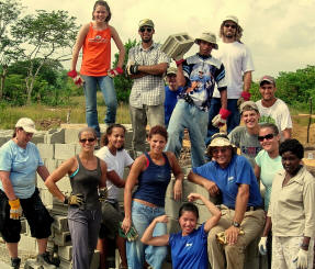 Volunteer team posing on a pile of concrete blocks