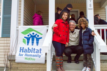 Happy family in front of new house