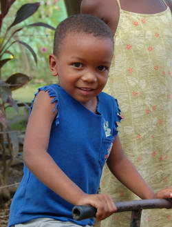 Child in a rural village riding a tricycle