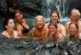 Volunteers swimming near waterfall