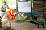Volunteer pressing long handle of brick machine